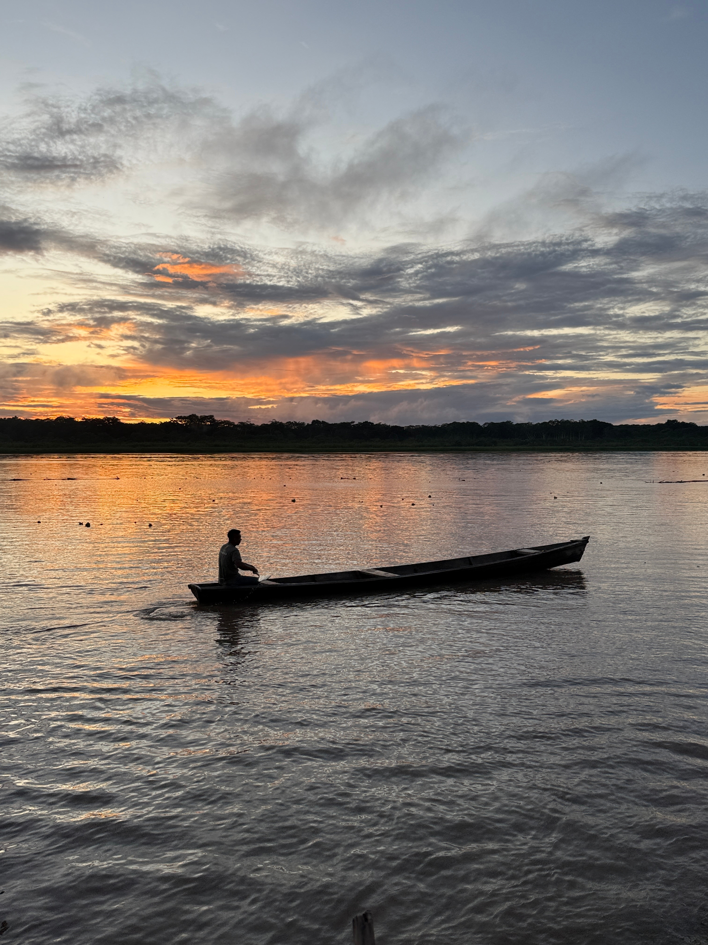 Atardecer en el río Amazonas con silueta de canoa